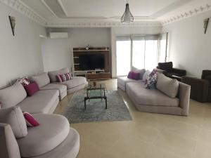 a living room with two couches and a television at Elegant appartement de 2 chambres sur bd Anfa in Casablanca