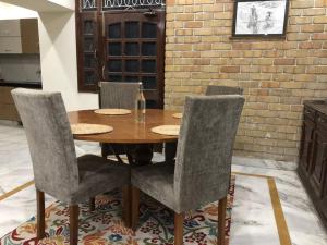 a dining room table with chairs and a brick wall at Spacious 5 Bedroom Park Facing House in Pānīpat +21 photos