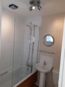 Un baño con ducha, lavabo e inodoro. en Upwey, en Weymouth