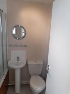 Un baño con inodoro, lavabo y espejo. en Upwey, en Weymouth 6 fotos más