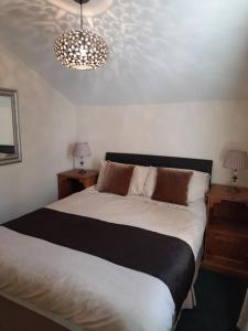 Un dormitorio con una cama con dos mesitas de noche y dos lámparas. en Upwey, en Weymouth