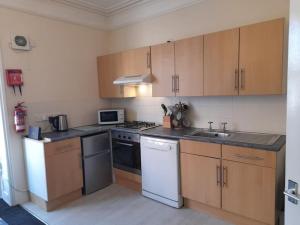 a kitchen with white appliances and wooden cabinets at Upwey in Weymouth