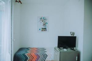 a room with a bed with a television on top at вила Лора in Sinemorets