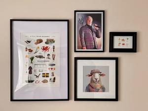 eine Wand mit Bildern von einem Mann und einem Kühlschrank in der Unterkunft Blackberry Cottage in Cardiff