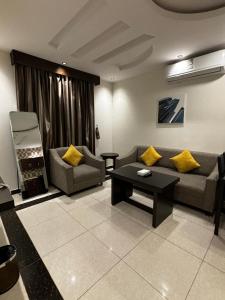 ein Wohnzimmer mit Sofa und Tisch in der Unterkunft Rosa Aparthotel in Buraida + 48 Fotos