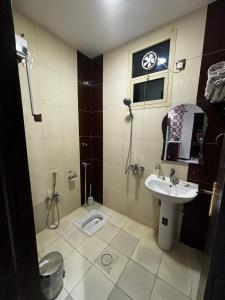 ein Badezimmer mit Waschbecken, Dusche und Toilette in der Unterkunft Rosa Aparthotel in Buraida