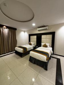 ein Hotelzimmer mit zwei Betten in einem Zimmer in der Unterkunft Rosa Aparthotel in Buraida