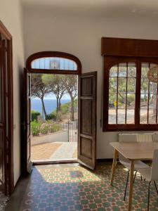 an open door to a room with a table and a view at Villa modernista Llafranc in Llafranc