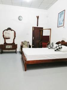 a bedroom with two beds and a mirror and a chair at Green Hill Villa in Unawatuna