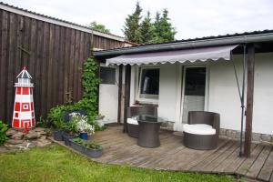 un ponte di legno con un faro e una casa di Ferienwohnung kleine Koje a Kröslin