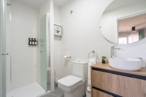 a bathroom with a toilet and a sink and a mirror at Apartamento Luxor en zona Hospital - Universidad in Albacete +21 photos