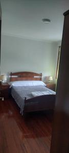 1 cama en un dormitorio con suelo de madera en Pensión Portus Marini, en Portomarín 8 fotos más