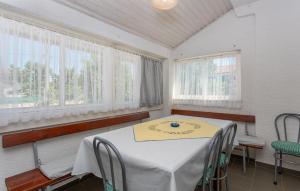 a dining room with a table and two windows at 2 Bedroom Amazing Apartment In Pinezici in Pinezici