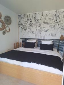 a bedroom with a large bed with a painting on the wall at TINY HOUSE avec piscine "La Bernadette" villa Sisyphe in Le Thoronet