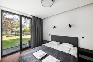 a bedroom with a bed and a large window at Juodasis Gintaras in Palanga