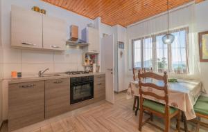 a kitchen with a table and a dining room at Gorgeous Apartment In Sveti Juraj in Sveti Juraj