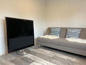a living room with a couch and a flat screen tv at Billund- Newly renovated 1 bedroom kitchen in Billund