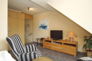 a living room with two chairs and a television at Apartmentanlage Eldena Ferienwohnung 10 in Lobbe