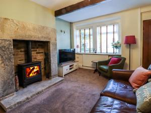 a living room with a fireplace and a couch at Emily Cottage in Keighley