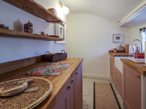 a kitchen with a wooden counter top and a sink at Emily Cottage in Keighley