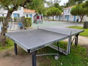 una mesa de ping pong frente a un parque infantil en Maison 4-6 personnes, en Saint-Brevin-les-Pins