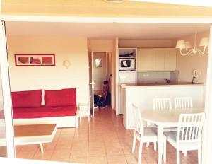 a living room with a red couch and a table at Petit cocon en Provence in Mallemort