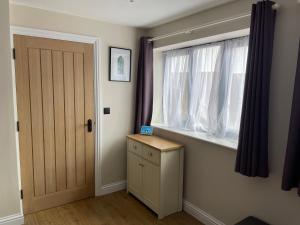 Zimmer mit einem Fenster und einer Holztür in der Unterkunft Blackberry Cottage in Cardiff