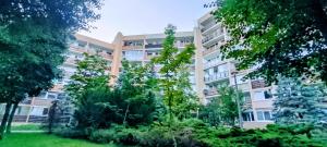 グダニスクにあるBlue Sky 1Studio Gdańskの目の前に木々が生い茂るアパートメント