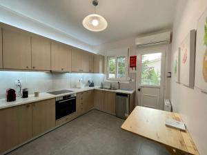 a kitchen with wooden cabinets and a wooden table at GS-Vibes in Porto Rafti