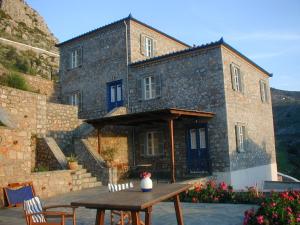 a large stone building with a table in front of it at Hydra Erato in Hydra