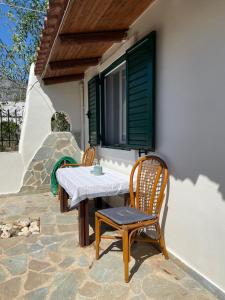 un tavolo e sedie su un patio con finestra di Μονοκατοικία Στο Λουτρακι a Loutraki
