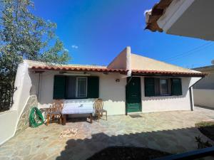una piccola casa bianca con tavolo e sedie di Μονοκατοικία Στο Λουτρακι a Loutraki Altre 4 foto