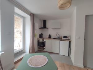 a kitchen with a table with a plate on top of it at Studio avec patio en centre-ville in Pontivy