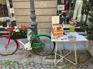 a bike parked next to a table with flowers at Bon Bon il Morelli in pieno centro no ztl in Asti