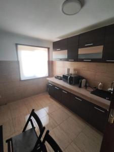a kitchen with black cabinets and a table and chairs at Apartament Luna in Jurilovca