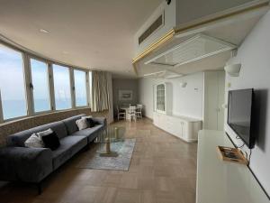 a living room with a couch and a television at Royal on the Sea in Netanya