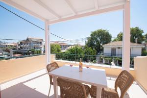 a white table with wine glasses on a balcony at CK Apartments in Nydri