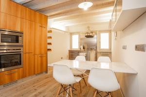 a kitchen with a large white table and white chairs at Casa del Sarto in Mantova