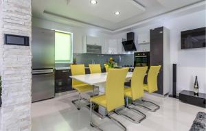 cocina con mesa de comedor y sillas amarillas en Cozy Apartment In Strozanac With Wifi, en Strožanac