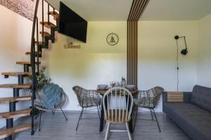 a dining room with a table and chairs and a couch at Pokoje Gościnne Malinówka in Krościenko
