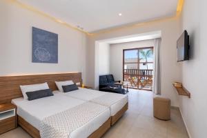 a bedroom with a large bed and a balcony at Costa Lindia Blue Star - Adults Only in Lartos +46 photos