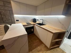 a small kitchen with white cabinets and a counter top at Studio Lazur in Burgas