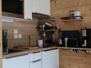 kuchnia z białymi szafkami i blatem w obiekcie À louer 2 pièces au pied des pistes, déco soignée, parking - FR-1-573-101 w mieście Saint-Jean-dʼAulps +14 zdjęć