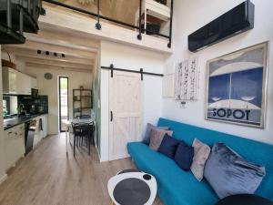 a living room with a blue couch and a kitchen at Sielanka na Roztoczu in Ciotusza Nowa