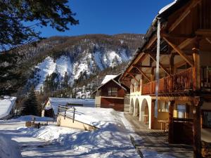 アルヴィユーにあるLa Centauréeの山を背景にした雪の丸太小屋