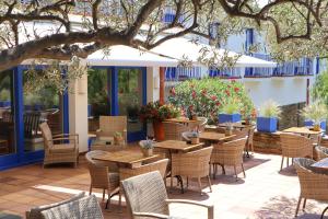 an outdoor patio with tables and chairs and flowers at Hotel Blaumar Cadaqués by Fimedhotels in Cadaqués