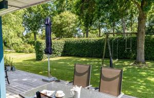 a table and chairs with an umbrella and a swing at 2 Bedroom Nice Home In Samsø in Samsø +10 photos
