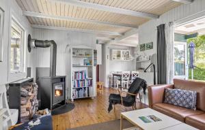 a living room with a couch and a wood stove at 2 Bedroom Nice Home In Samsø in Samsø