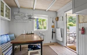 a kitchen with a table and a refrigerator at 2 Bedroom Nice Home In Samsø in Samsø