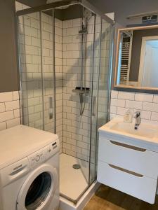 ein Badezimmer mit Waschmaschine und Waschbecken in der Unterkunft Przytulna kawalerka nad Jeziorem Długim darmowy parking i rowery in Olsztyn